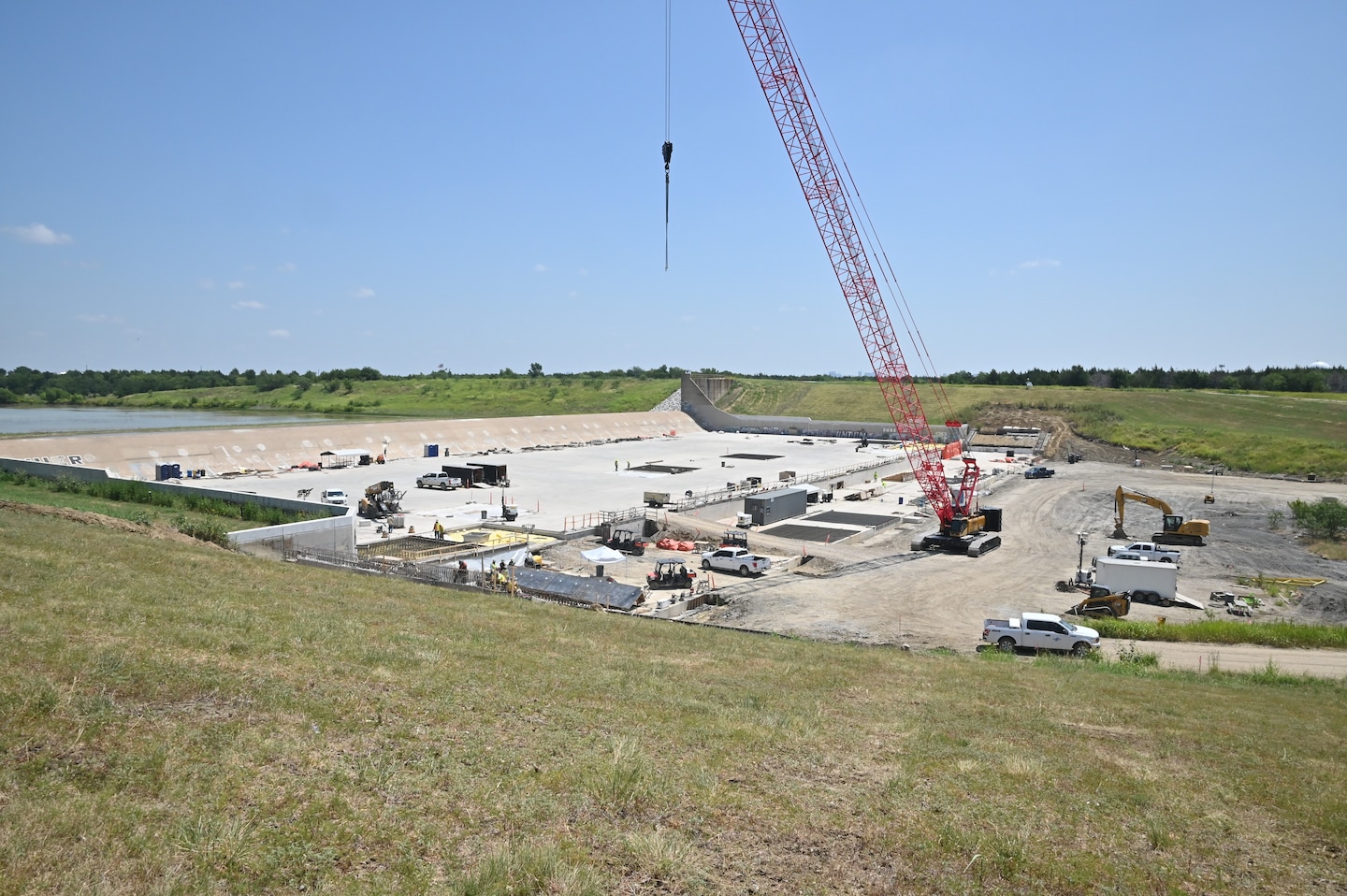 An overhead view of the Lewisville Lake spillway. Construction crews have installed more than 70 high-capacity post-tensioned anchors through the spillway weir and into the underlying bedrock. These anchors increase the spillway's resistance to uplift forces and improve overall structural stability. In addition, engineers installed an upstream geomembrane blanket designed to limit seepage beneath the spillway, reducing water pressures that can develop beneath the concrete during flood operations. Additional improvements include reinforcing portions of the spillway apron with 936 rock dowels and restoring disturbed areas once construction is complete.