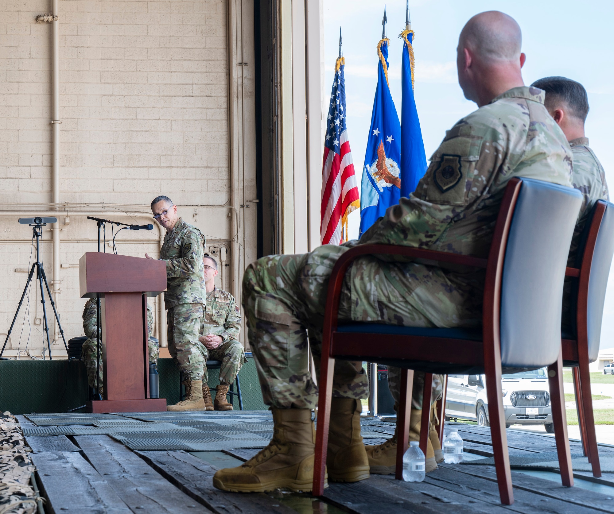 Lt. Gen. Thomas K. Hensley (at podium), commander of 16th Air Force (Air Forces Cyber) expresses his appreciation to the outgoing and incoming commanders of the Air Force Technical Applications Center, Col. Creighton Mullins (far right) and Col. Mark Brow (left) during the center’s Change of Command ceremony July 24, 2026, Patrick Space Force Base, Fla.  (U.S. Air Force photo by Matthew S. Jurgens)