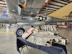 A fragment of a World War II P‑38 Lightning aircraft is displayed at the Experimental Aircraft Association’s AirVenture in Oshkosh, Wisconsin, July 23, 2026. The Wisconsin National Guard assisted in recovering and transporting aircraft components from Papua New Guinea as part of an effort to bring home the historic fighter that U.S. Army Air Forces Maj. Richard I. Bong flew and named 