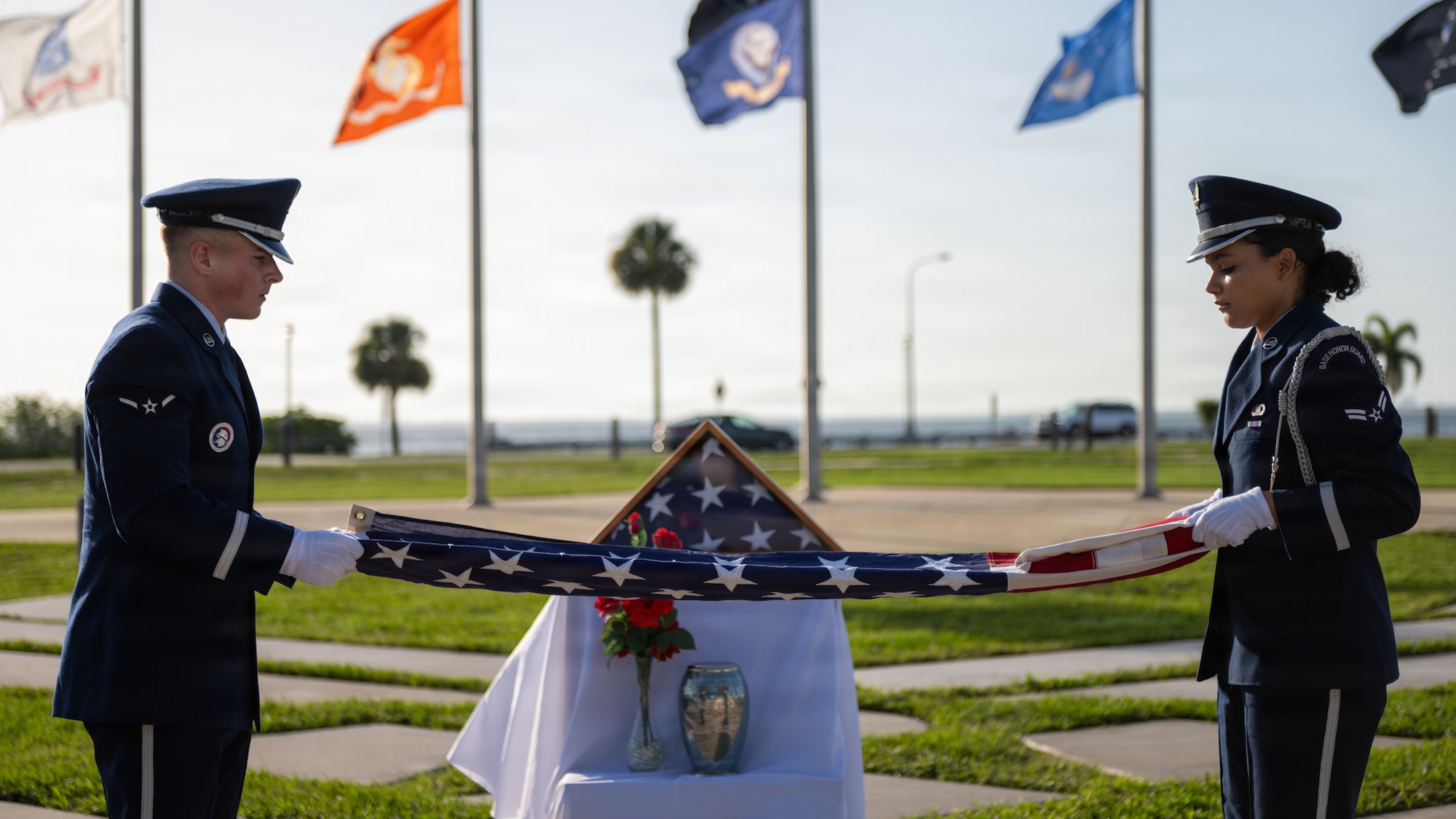 U.S. Air Force Airman Caden Stevens, left, and Airman 1st Class Marie Allegra, 6th Force Support Squadron ceremonial guardsmen, fold a ceremonial U.S. flag during a base honor guard induction ceremony at MacDill Air Force Base, Florida, July 22, 2026. Stevens and Allegra were among ten other Airmen to be inducted into the base honor guard during the most recent ceremony. (U.S. Air Force photo by Senior Airman Derrick Bole)
