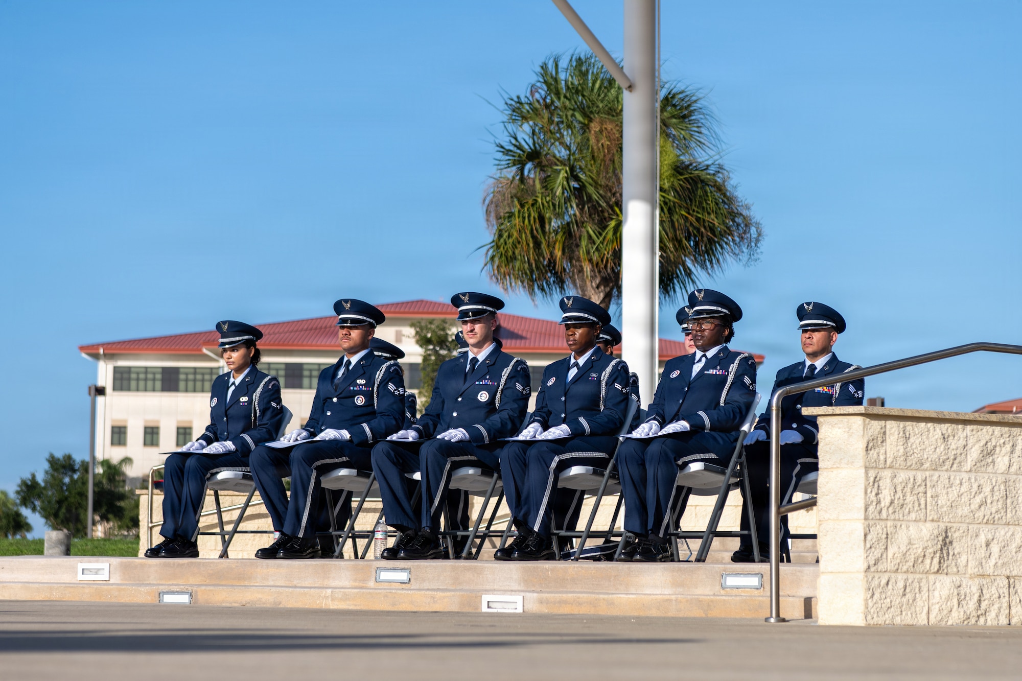 U.S. Air Force ceremonial guardsmen assigned to the 6th Force Support Squadron sit at attention during a base honor guard induction ceremony at MacDill Air Force Base, Florida, July 22, 2026. Ceremonial guardsmen perform duties ranging from funeral honors, where one or multiple flags are presented to the next of kin during a funeral, to colors presentation at local and installation events. (U.S. Air Force photo by Senior Airman Derrick Bole)
