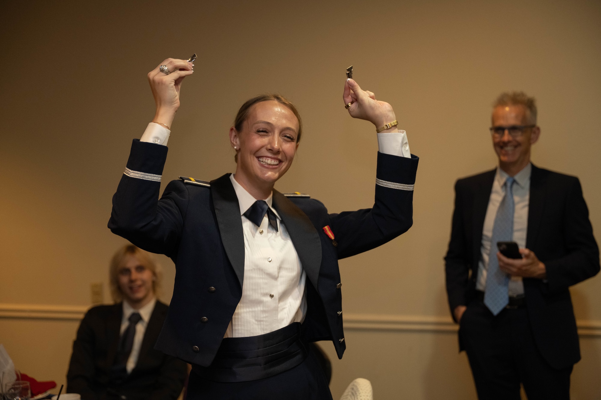 U.S. Air Force 2nd Lt. Ella Duncan, 47th Student Squadron student pilot, holds up their broken silver wings during the graduation ceremony of Class 26-14 and 26-12 AU at Laughlin Air Force Base, Texas, July 23, 2026. The breaking of silver wings is a tradition dating back to the U.S. Army Air Corps where a pilot's first wings are not to be worn but broken and given to a loved one. (U.S. Air Force photo by Airman 1st Class Darryl Keith)