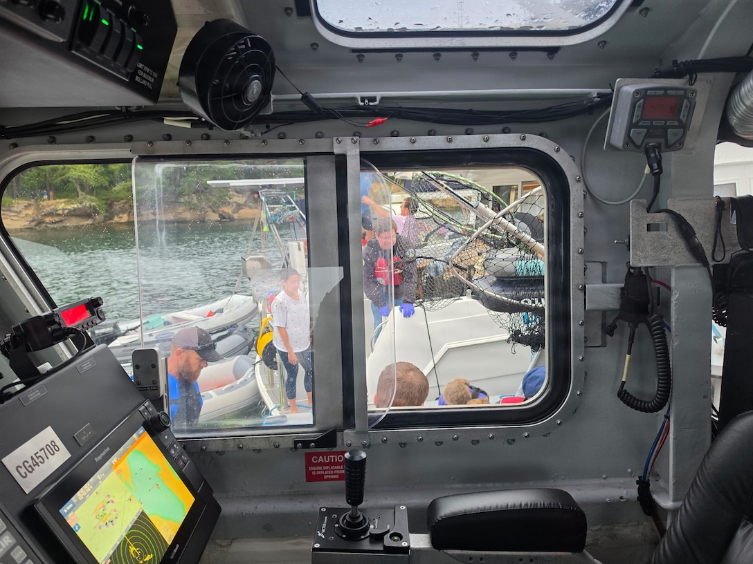 Good Samaritans transfer survivors to a U.S. Coast Guard Station Bellingham 45-foot Response Boat-Medium after a seaplane conducted an emergency landing