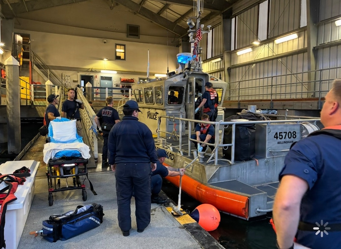 Members of U.S. Coast Guard Station Bellingham and Bellingham Fire Department prepare to transfer a survivor to emergency medical services personnel