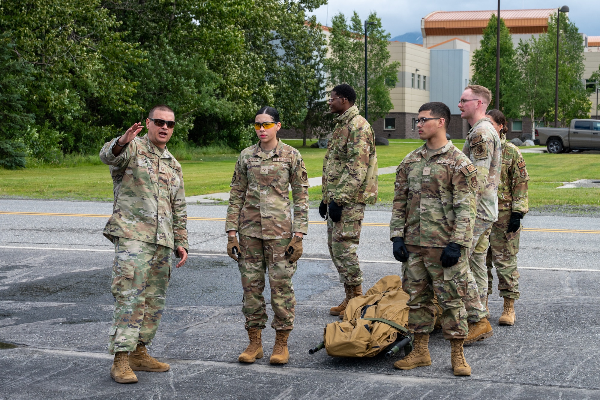 U.S. Air Force Master Sgt. Robert Smalling, left, 673d Medical Group flight chief, explains to MDG personnel on how to properly load a patient into the HH-60W Jolly Green II assigned to the 176th Wing Alaska Air National Guard, during a medical evacuation exercise at Joint Base Elmendorf-Richardson, Alaska, July 15, 2026.