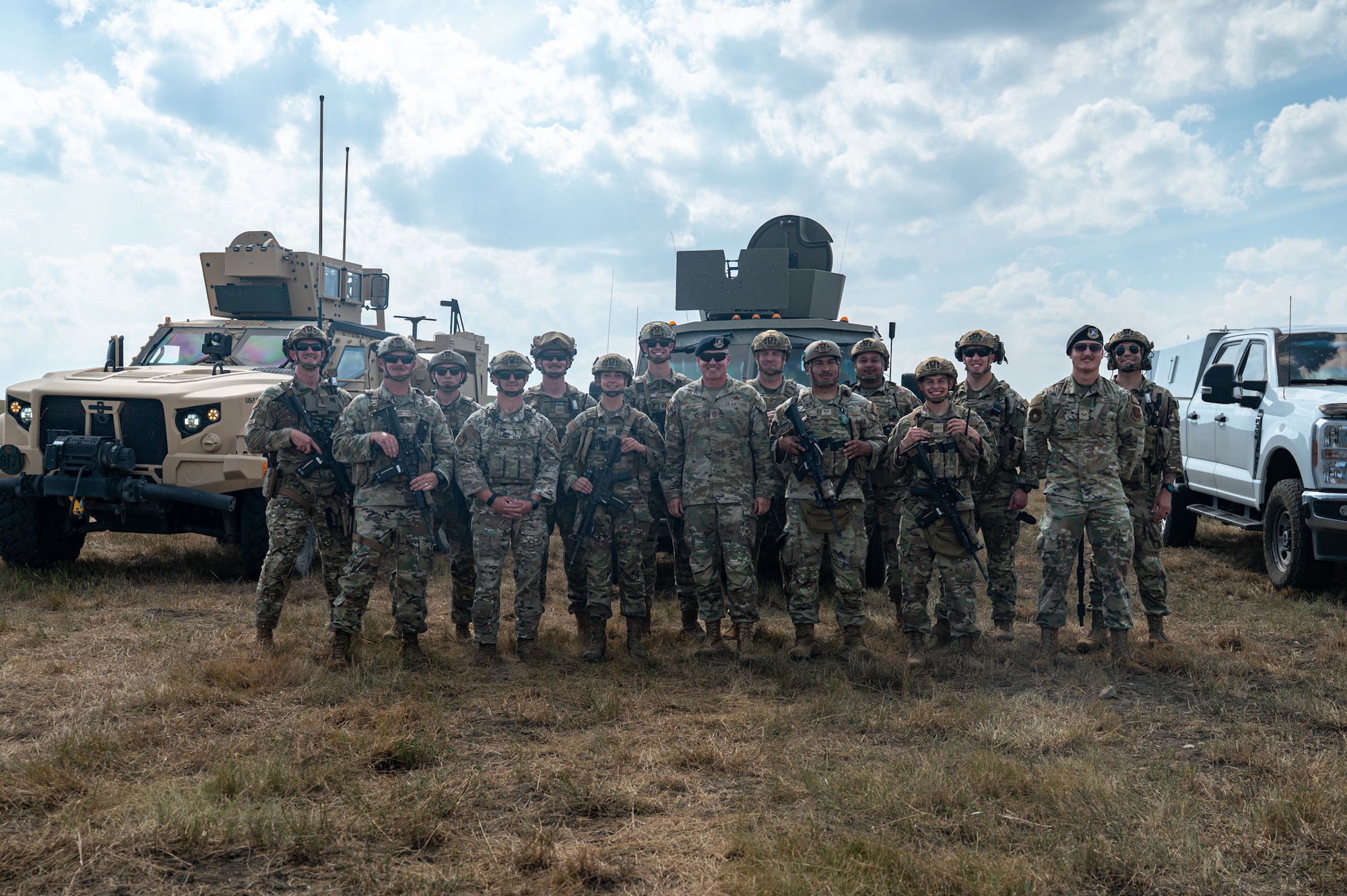 A group photo of military members all wearing camouflage uniforms.