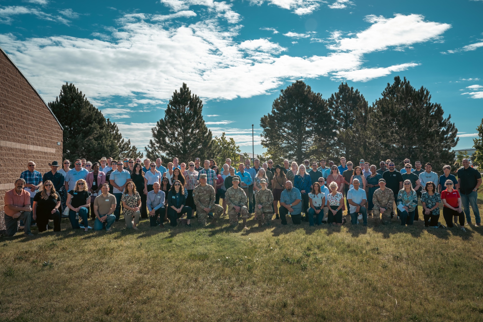 about one hundred people pose for a photo in a grass field