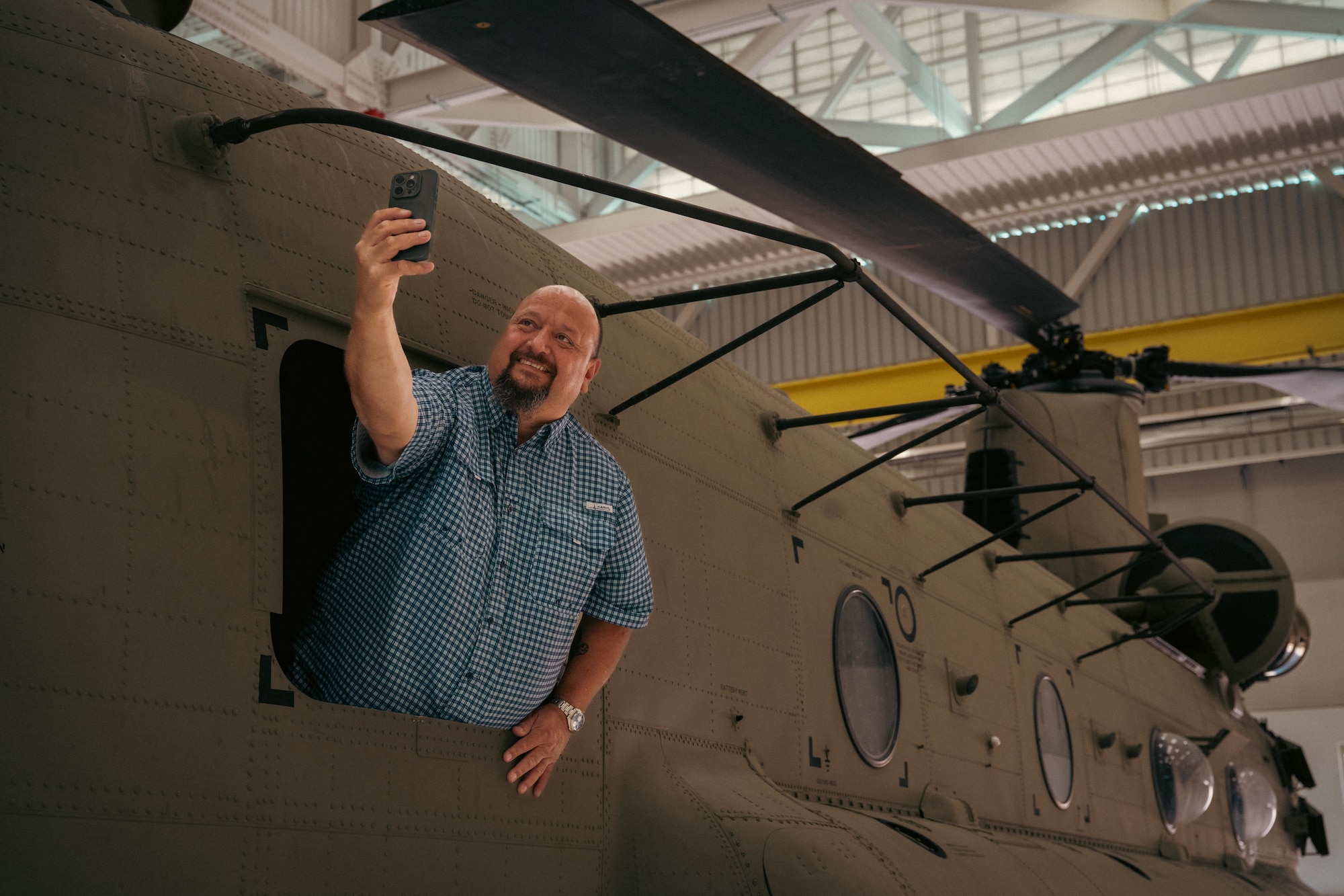 a man takes a selfie out of the window of a helicopter