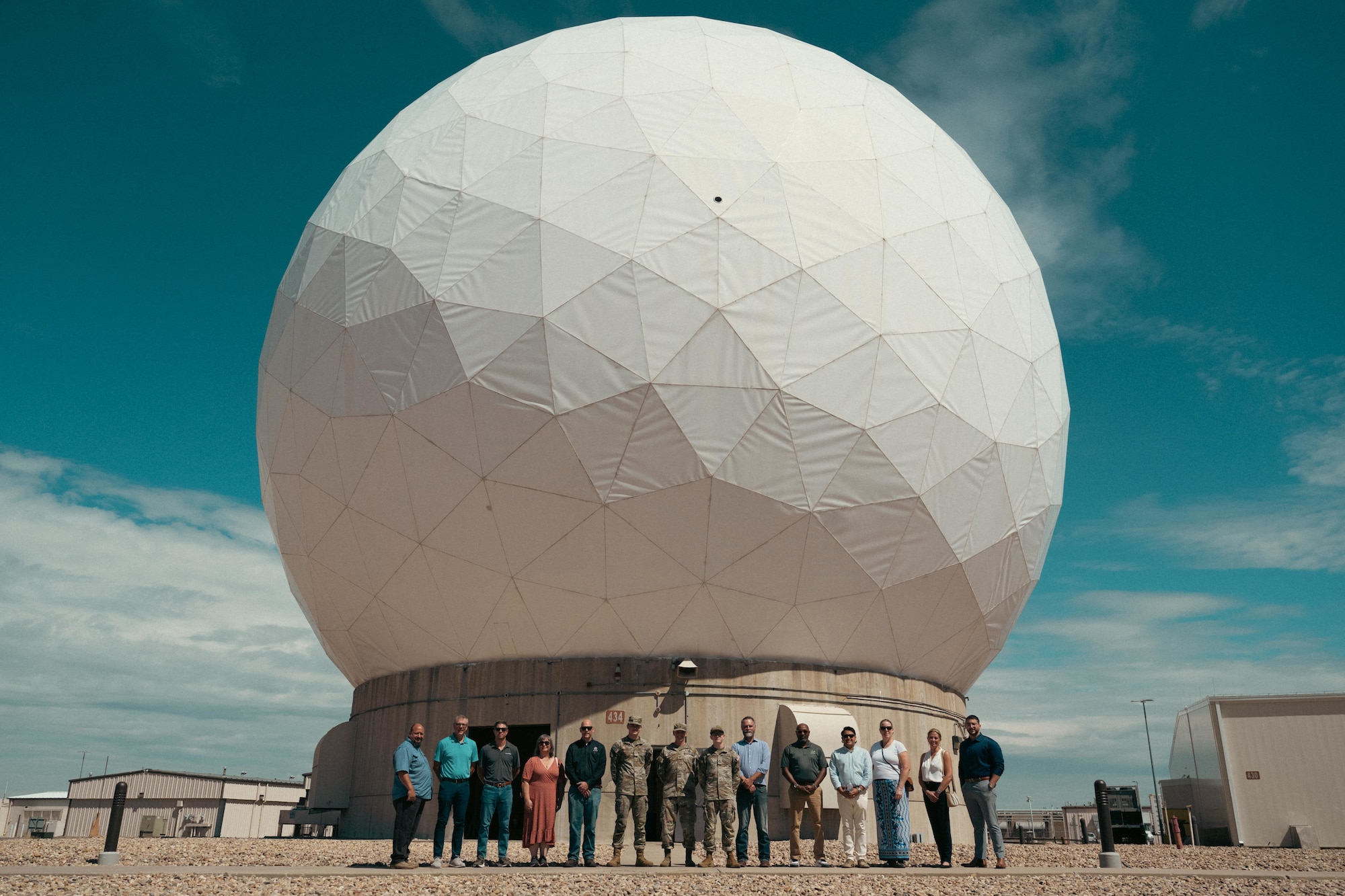 people pose in front of a radome