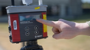 An Airman uses a QUESTemp 32 Area Heat Stress Monitors to measure air temperature, humidity, wind speed and sun angle at Spangdahlem Air Base, Germany, June 25, 2026. During periods of high heat, the team relays measurements to the wing's command post every 30 minutes  to inform decision makers and align with personnel protection measures with current heat conditions to reduce heat related illnesses. (U.S. Air Force photo by Staff Sgt. Darius Frazier)