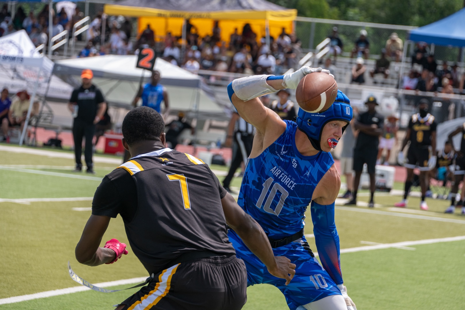 U.S. Air Force Staff SGt. Haydn Wall, stationed at Joint Base Pearl Harbor-Hickan, Hawaii, dodges a defender during the Armed Forces Flag Football Championships at Cougar Stadium on Fort Sam Houston, Texas, July 25, 2026. Service members competed for championship honors while representing their respective services. Armed Forces sports bring together service members from the Army, Marine Corps, Navy (with Coast Guard athletes), and Air Force (with Space Force athletes) to compete at the national level. Armed Forces Sports pormotes physicl fitness, provides competitive opportunities for military athletes at national and international levels, supports recruitment and retention efforts, and strengthens partnerships through sports diplomacy. (U.S. Air Force photo by Staff Sgt. Jonathan Anderson)