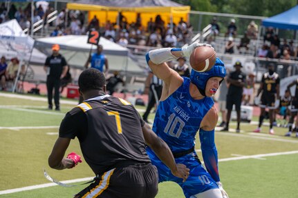 U.S. Air Force Staff SGt. Haydn Wall, stationed at Joint Base Pearl Harbor-Hickan, Hawaii, dodges a defender during the Armed Forces Flag Football Championships at Cougar Stadium on Fort Sam Houston, Texas, July 25, 2026. Service members competed for championship honors while representing their respective services. Armed Forces sports bring together service members from the Army, Marine Corps, Navy (with Coast Guard athletes), and Air Force (with Space Force athletes) to compete at the national level. Armed Forces Sports pormotes physicl fitness, provides competitive opportunities for military athletes at national and international levels, supports recruitment and retention efforts, and strengthens partnerships through sports diplomacy. (U.S. Air Force photo by Staff Sgt. Jonathan Anderson)