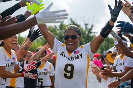U.S. Army 1st Lt. Ky'achia Carey, stationed at Fort Bragg, North Carolina, high fives teammates during the Armed Forces Flag Football Championships at Cougar Stadium on Fort Sam Houston, Texas, July 25, 2026. Service members competed for championship honors while representing their respective services. Armed Forces sports bring together service members from the Army, Marine Corps, Navy (with Coast Guard athletes), and Air Force (with Space Force athletes) to compete at the national level. Armed Forces Sports pormotes physicl fitness, provides competitive opportunities for military athletes at national and international levels, supports recruitment and retention efforts, and strengthens partnerships through sports diplomacy. (U.S. Air Force photo by Staff Sgt. Jonathan Anderson)