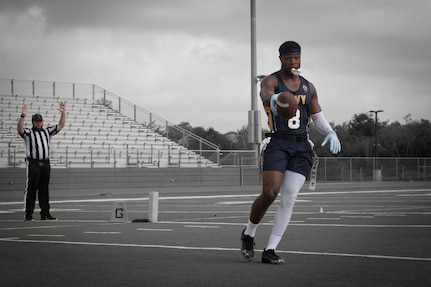 U.S. Navy Petty Officer 2nd Class Marquiste Jackson, stationed at Naval Air Station Jacksonville, Florida, scores a touchdown during the Armed Forces Flag Football Championships at Cougar Stadium on Fort Sam Houston, Texas, July 25, 2026. Service members competed for championship honors while representing their respective services. Armed Forces sports bring together service members from the Army, Marine Corps, Navy (with Coast Guard athletes), and Air Force (with Space Force athletes) to compete at the national level. Armed Forces Sports pormotes physicl fitness, provides competitive opportunities for military athletes at national and international levels, supports recruitment and retention efforts, and strengthens partnerships through sports diplomacy. (U.S. Marine Corps photo by Cpl. Diana Salgado)