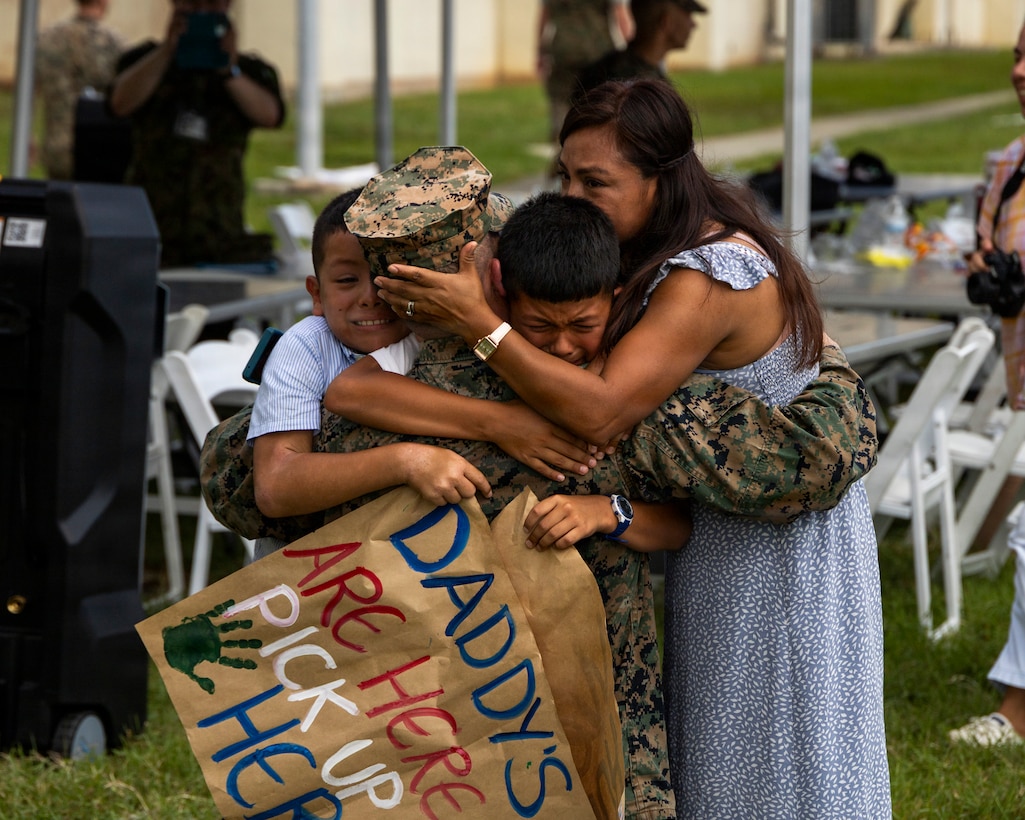 A Marine returning from deployment with the 31st Marine Expeditionary Unit embraces his family at Camp Hansen, Okinawa, Japan, July 22, 2026.
