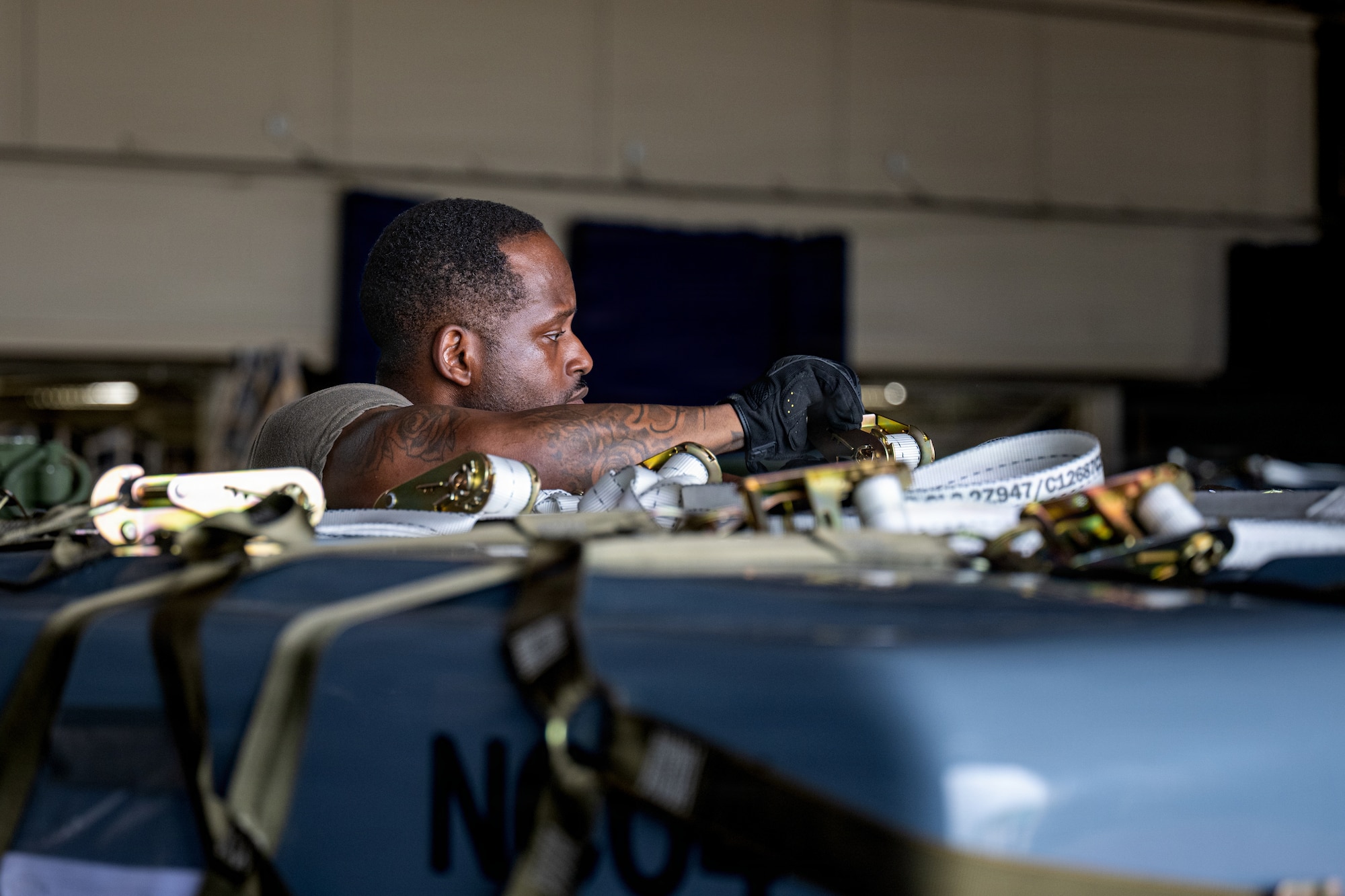 U.S. Air Force Tech. Sgt. Sean Porterfield, 35th Maintenance Squadron inspections noncommissioned officer in charge, secures cargo in support of Red Flag-Alaska 26-3.