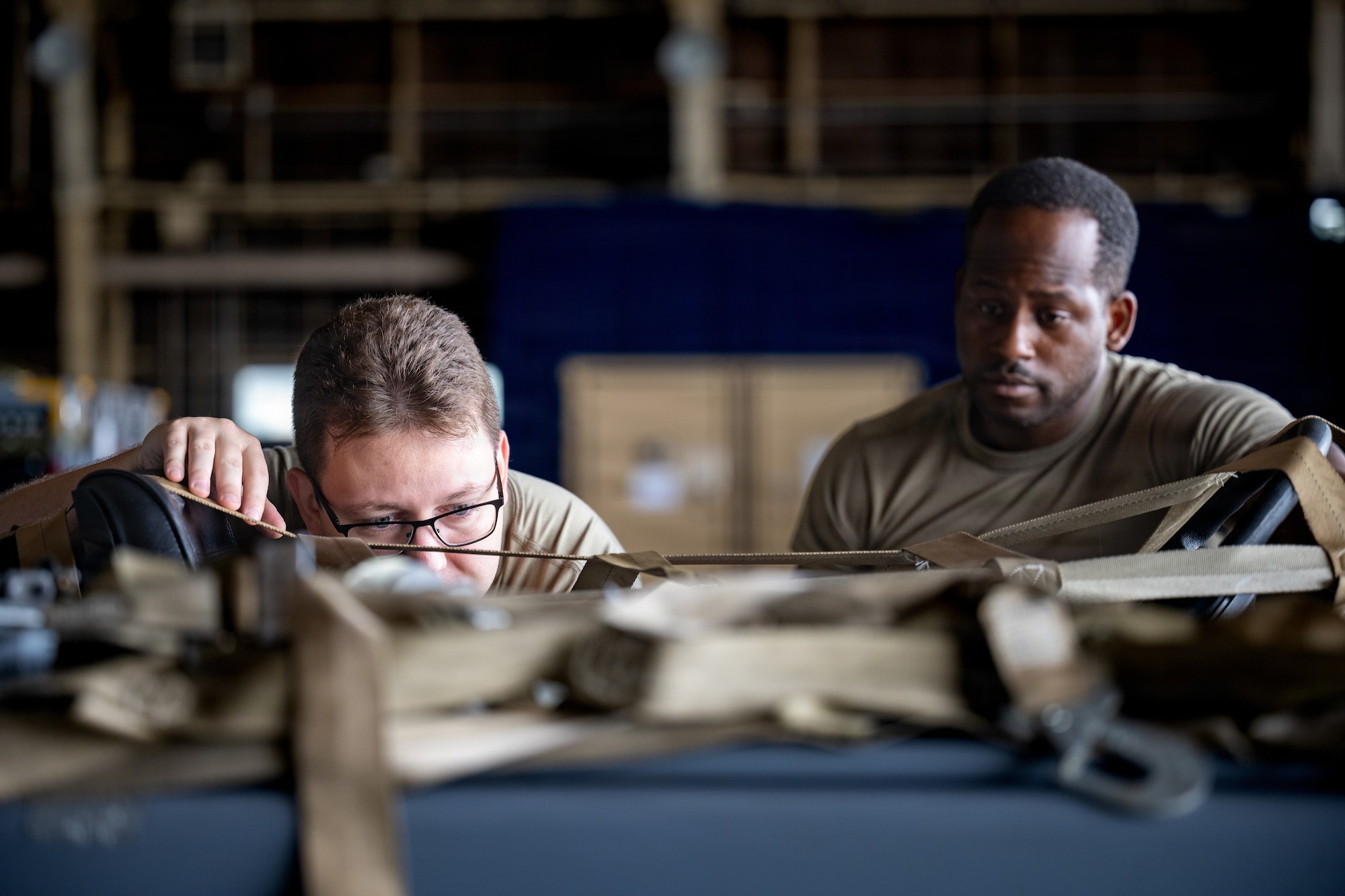 U.S. Air Force Staff Sgt. Christian Shank, 35th Logistics Readiness Squadron air transportation function supervisor, left, and Tech. Sgt. Sean Porterfield, 35th Maintenance Squadron inspections noncommissioned officer in charge, inspect cargo in support of Red Flag-Alaska 26-3.
