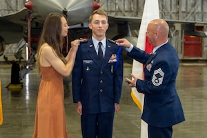 U.S. Civil Air Patrol Cadet Col. Cayne Redmond, center, has the rank of cadet colonel pinned by his parents during his General Carl A. Spaatz Award ceremony at Misawa Air Base, Japan,