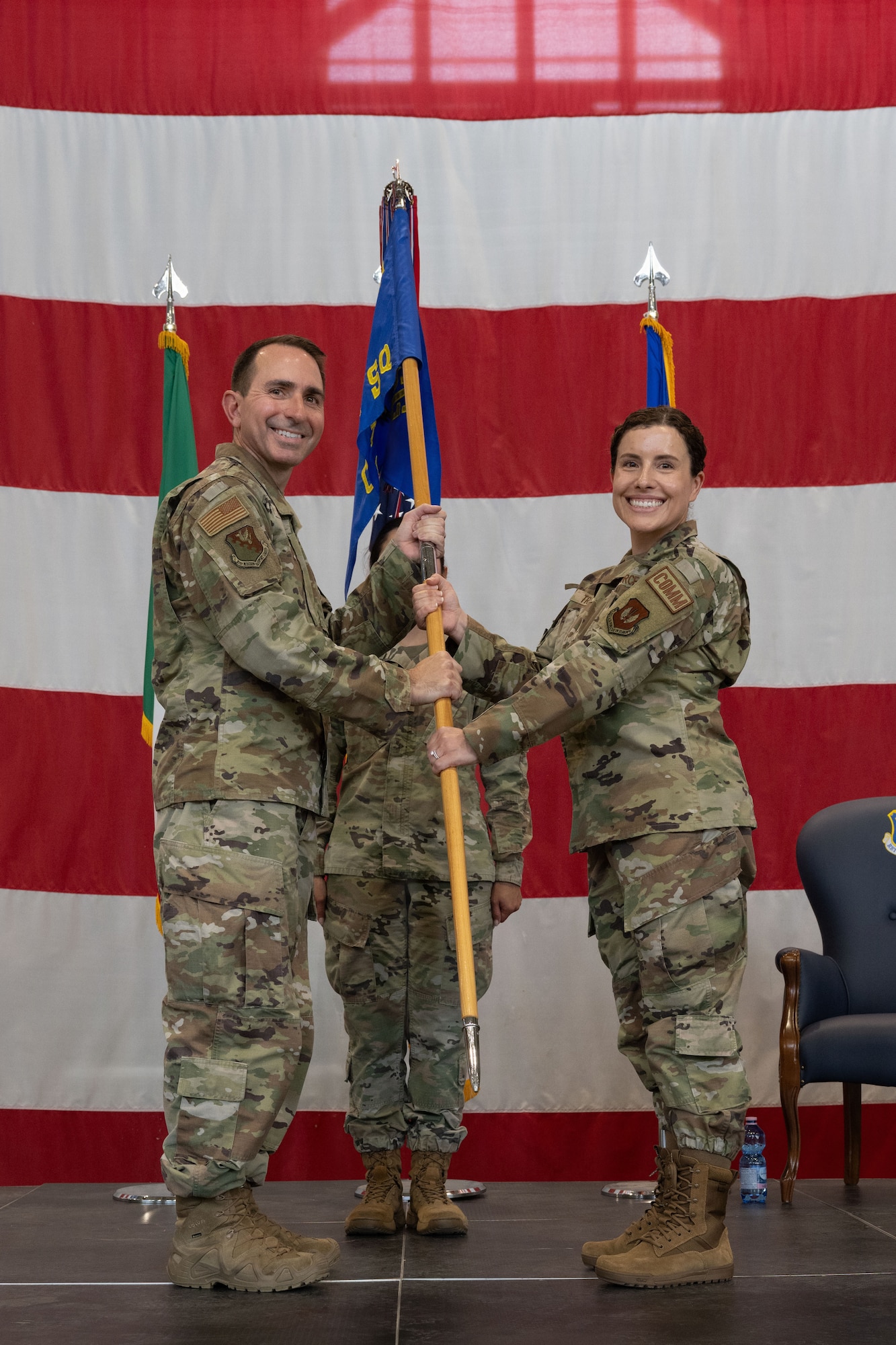 A man hands a guidon to a woman.