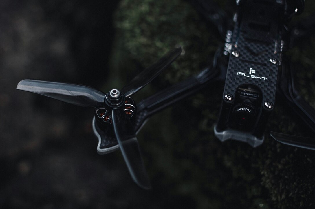 Close-up photograph of a black iFlight FPV drone equipped with a Caddx camera system.