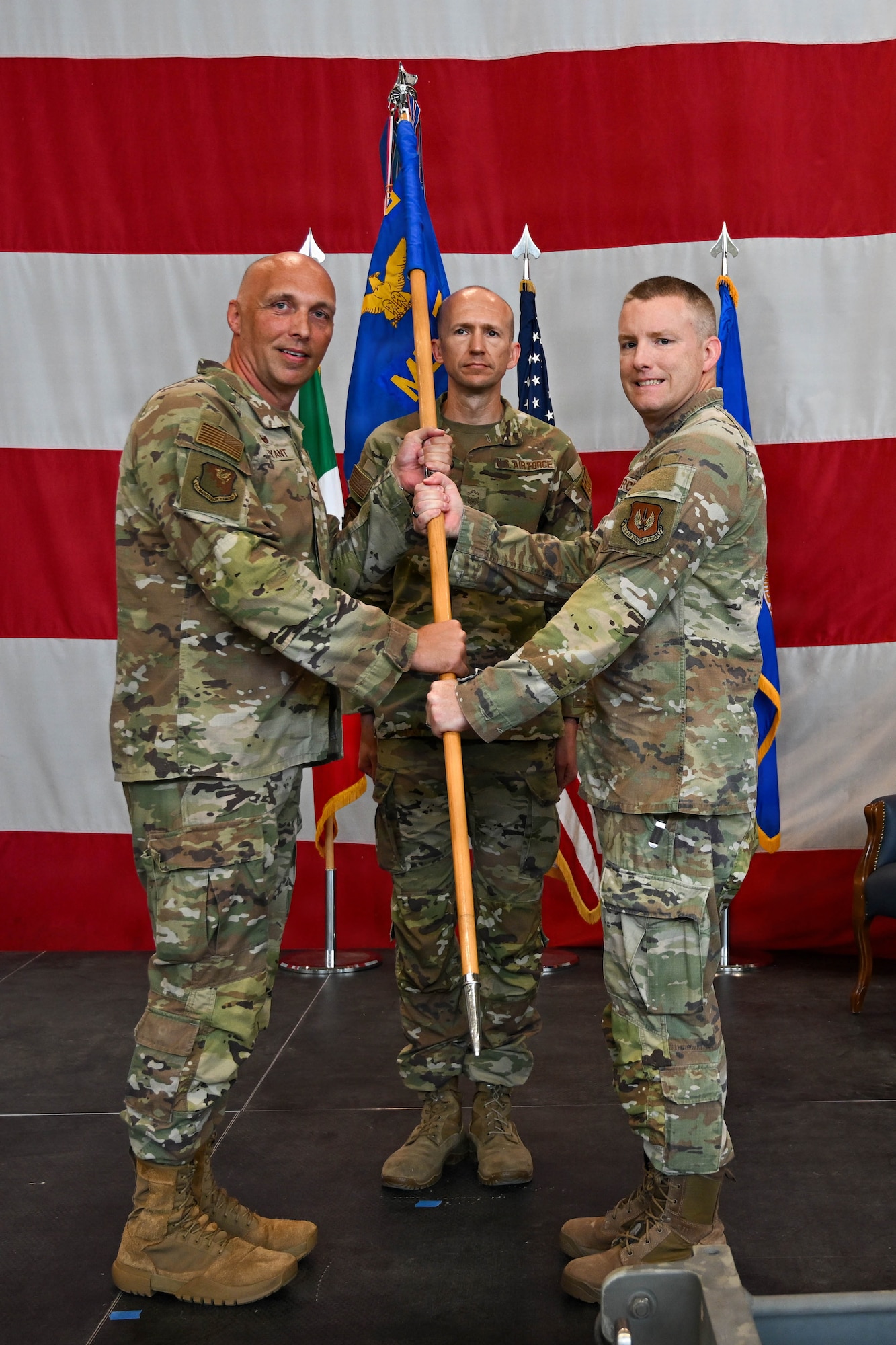 A man passes a guidon to another man.