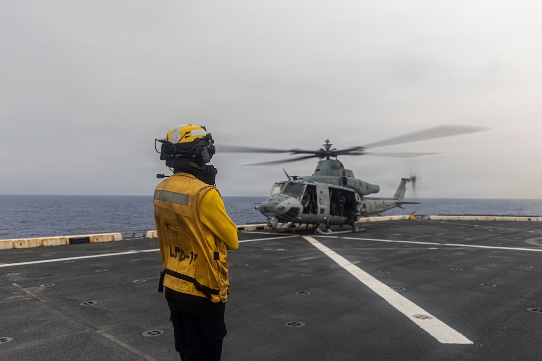 A U.S. Sailor, assigned to San Antonio-class amphibious transport dock USS San Antonio (LPD 17), signals to a U.S. Marine Corps UH-1Y Venom, assigned to Marine Medium Tiltrotor Squadron (VMM) 365 (Reinforced), Littoral Combat Force-24, during deck landing qualifications while underway in the Caribbean Sea, July 23, 2026. U.S. military forces are deployed to the U.S. Southern Command area of responsibility in support of Operation SOUTHERN SPEAR, Department of War-directed operations, and the president’s priorities to disrupt illicit drug trafficking, deter malign actors and protect the homeland through continuous presence. (U.S. Marine Corps photo)