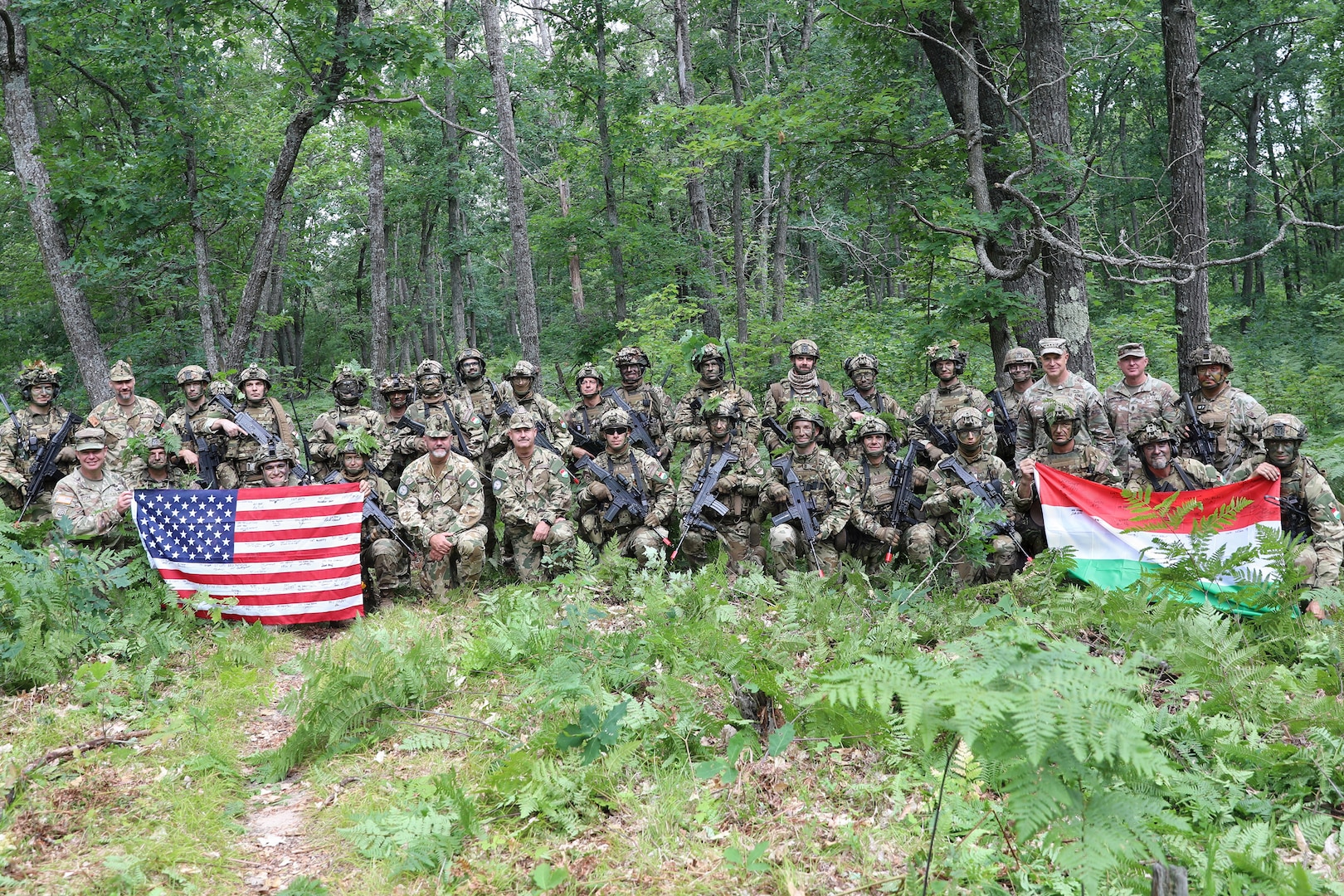 Lt. Gen. Jonathan Stubbs, director of the Army National Guard, and Command Sgt. Maj. Brian Kendrick, command sergeant major of the Army National Guard, pose with U.S. and Hungarian service members during Combat Readiness Exercise 26-01 at Camp Grayling Joint Maneuver Training Center, Michigan, July 21, 2026.