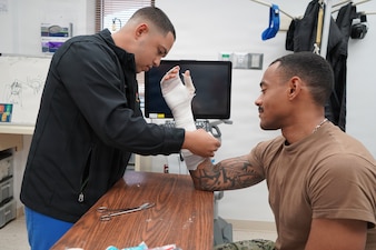 Hospital Corpsman 3rd Class Ramon A. Diaz, assigned to Navy Medicine Readiness and Training Command Rota's Orthopedics Clinic, applies orthopedic casting material to a service member at Naval Station Rota, March 15, 2026 As an orthopedic technician, Diaz provides specialized treatment for musculoskeletal injuries, helping Sailors and Marines recover and return to duty. (U.S. Navy photo by Lt. Cmdr. Alicia Sacks)