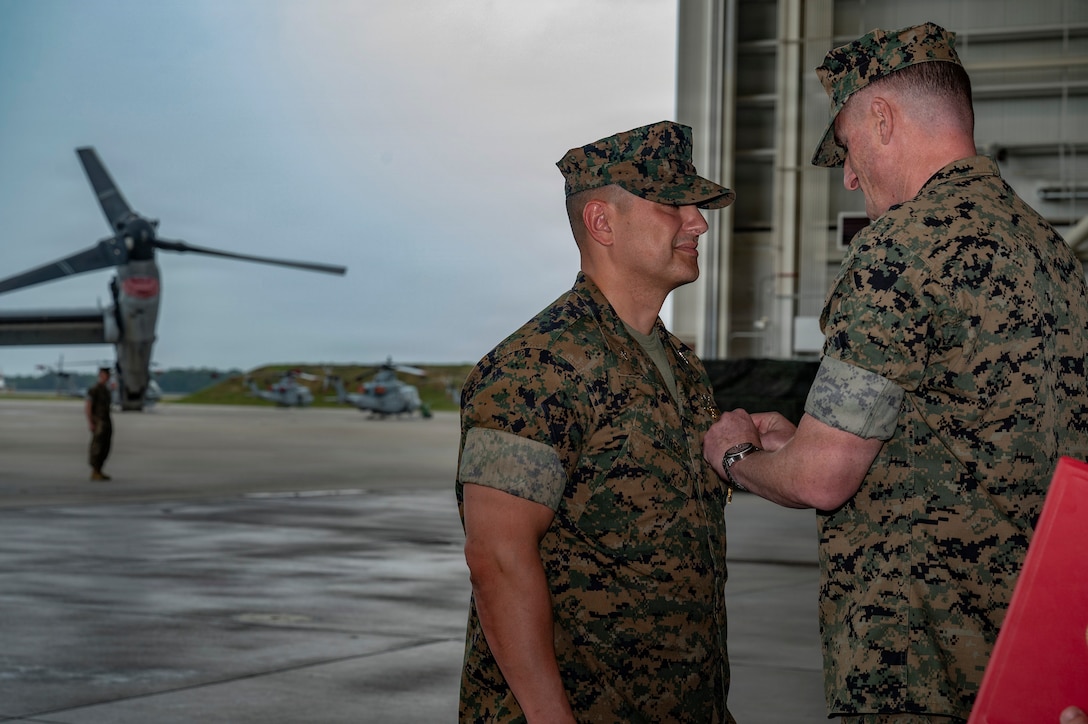 U.S. Marine Corps Brig. Gen. Patrick Tiernan, 4th Marine Aircraft Wing commanding general, attaches the Legion of Merit award to Col. Pablo Torres, left, outgoing Marine Aircraft Group (MAG) 49 commander, during a change of command ceremony at Joint Base McGuire-Dix-Lakehurst, N.J., June 27, 2026. Torres received the award for his performance while serving as the commanding officer of Mag-49 from June 2024 to June 2026. (U.S. Air Force photo by Airman 1st Class Francine D. Martin)