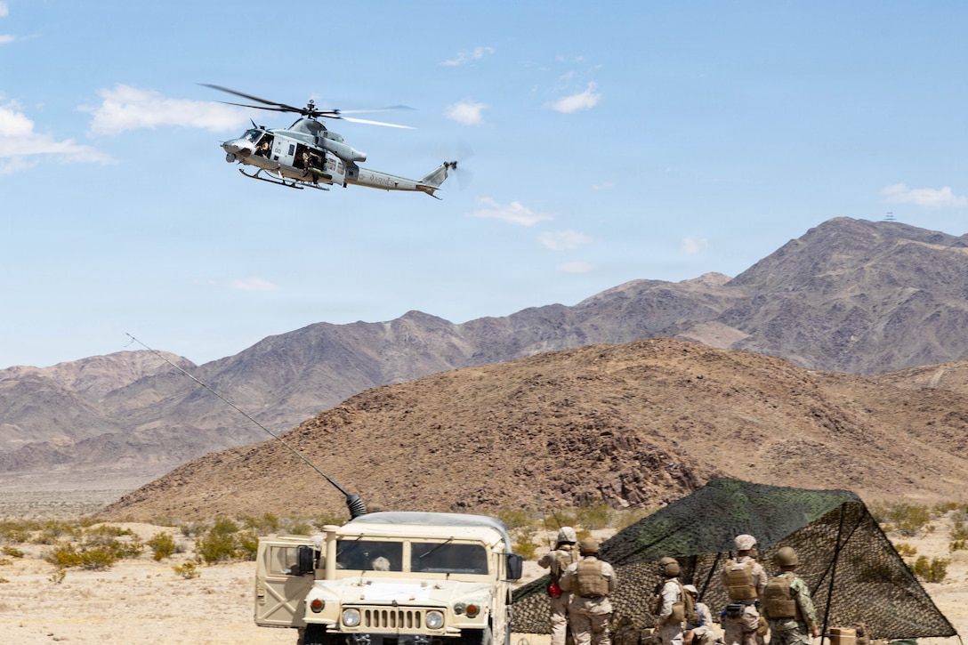 U.S. Marines with Marine Wing Support Squadron 473 (MWSS-473), Marine Aircraft Group 41, 4th Marine Aircraft Wing, observe a UH-1 Venom during a Forward Arming and Refueling Point exercise as part of Service Level Training Exercise 3-26 at training area Cleghorn, Marine Corps Air Ground Combat Center, Twentynine Palms, California, June 15, 2026. Service level training exercise assesses Marine Air Ground Task Forces abilities to plan, coordinate and execute large-scale operations by integrating command and control, maneuver, sustainment and live-fire events in realistic training environments. (U.S. Marine Corps photo by Lance Cpl. Cody Fitzgerald)