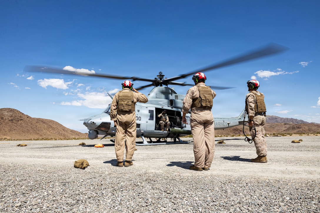 U.S. Marines with Marine Wing Support Squadron 473 (MWSS-473), Marine Aircraft Group 41, 4th Marine Aircraft Wing, salute the crew of a UH-1 Venom during a Forward Arming and Refueling Point exercise as part of Service Level Training Exercise 3-26 at training area Cleghorn, Marine Corps Air Ground Combat Center, Twentynine Palms, California, June 15, 2026. Service level training exercise assesses Marine Air Ground Task Forces abilities to plan, coordinate and execute large-scale operations by integrating command and control, maneuver, sustainment and live-fire events in realistic training environments. (U.S. Marine Corps photo by Lance Cpl. Cody Fitzgerald)