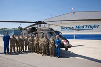 Soldiers from the Massachusetts National Guard's Detachment 1, C Company, 3rd Battalion, 126th Aviation Regiment, General Support Aviation Battalion, and leadership from the 3rd Battalion, 126th Aviation Regiment, General Support Aviation Battalion and 151st Regional Support Group pose for a photo in front of a Black Hawk with instructors from Boston MedFlight outside of the Boston MedFlight hangar, July 17, 2026.