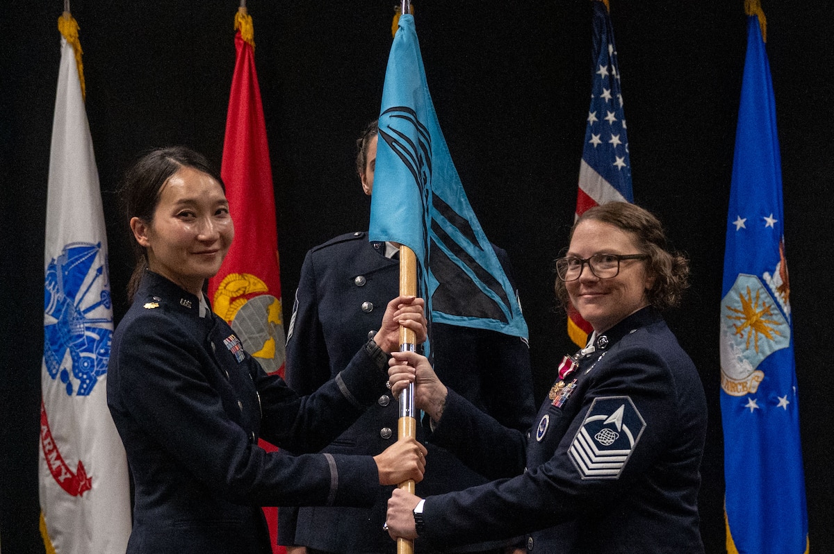 U.S. Space Force Maj. Uiri Han, 533rd Training Squadron, Detachment 1 commander, passes the guidon to Master Sgt. Cathy Nikolauk, outgoing detachment senior enlisted leader, during the change of responsibility ceremony at Goodfellow Air Force Base, Texas, July 21, 2026. The change of responsibility ceremony is steeped in military tradition, serves the function of rendering honors to the departing senior enlisted leader and provides official recognition of the transfer of responsibility to the incoming senior enlisted leader. (U.S. Air Force photo by Senior Airman James Salellas)