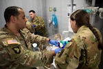 Sgt. 1st Class Jose Morales, left, and Sgt. Stephannie LaCasse, both flight medics with the Massachusetts National Guard Detachment 1, C Company, 3rd Battalion, 126th Aviation Regiment, General Support Aviation Battalion, use an artificial manual breathing unit on a medical simulation mannequin in the Boston MedFlight simulation training center at their Bedford, Massachusetts headquarters, July 17, 2026. The training is part of a critical care training course. Photo by Sgt. 1st Class Steven Eaton.
