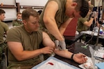 U.S. Army Cpt. Dan Walton, assigned to the Fort Hood Family Medicine Residency, inspects the needle inserted into the U.S. Army Soldier, Joseph Smith, assigned to the 19th Army Health Center, to ensure the needle was put in safely on Fort Hood, Texas, Jun. 1, 2026. JEMX-26 provides interoperability across Army, Navy, and Air Force medical teams and NATO partners with unparalleled hands-on training in combat casualty care. This rigorous, multi-service training prepares military medical personnel to operate and deliver critical care in challenging, complex operational environments. (U.S. Army photo by Sgt. Adel Pacheco Alvarez)
