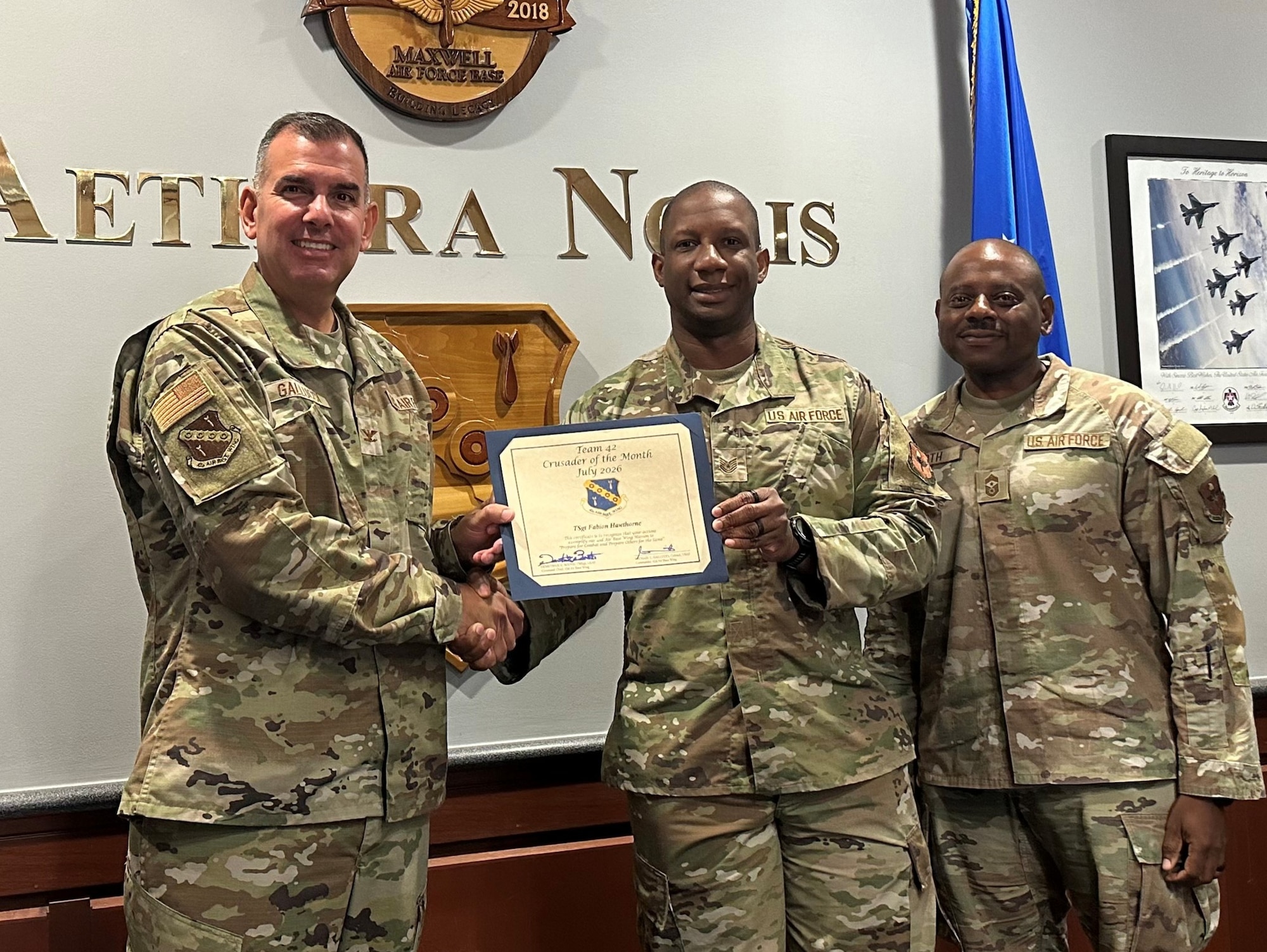 42d Air Base Wing Commander, U.S. Air Force Col. Mike Gallucci, presents a certificate to U.S. Air Force Tech. Sgt. Fabion Hawthorne, 42d Air Base Wing Inspector General Wing Inspections coordinator, recognizing him as Crusader of the Month, 22 July, 2025. The Crusader of the Month program recognizes 42d ABW Airmen whose leadership, performance and service make a significant contribution to the wing’s mission. (U.S. Air Force photo by Tech. Sgt. Savannah Waters)