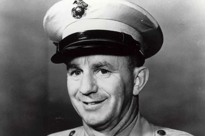A man in a formal military uniform poses for a photo.