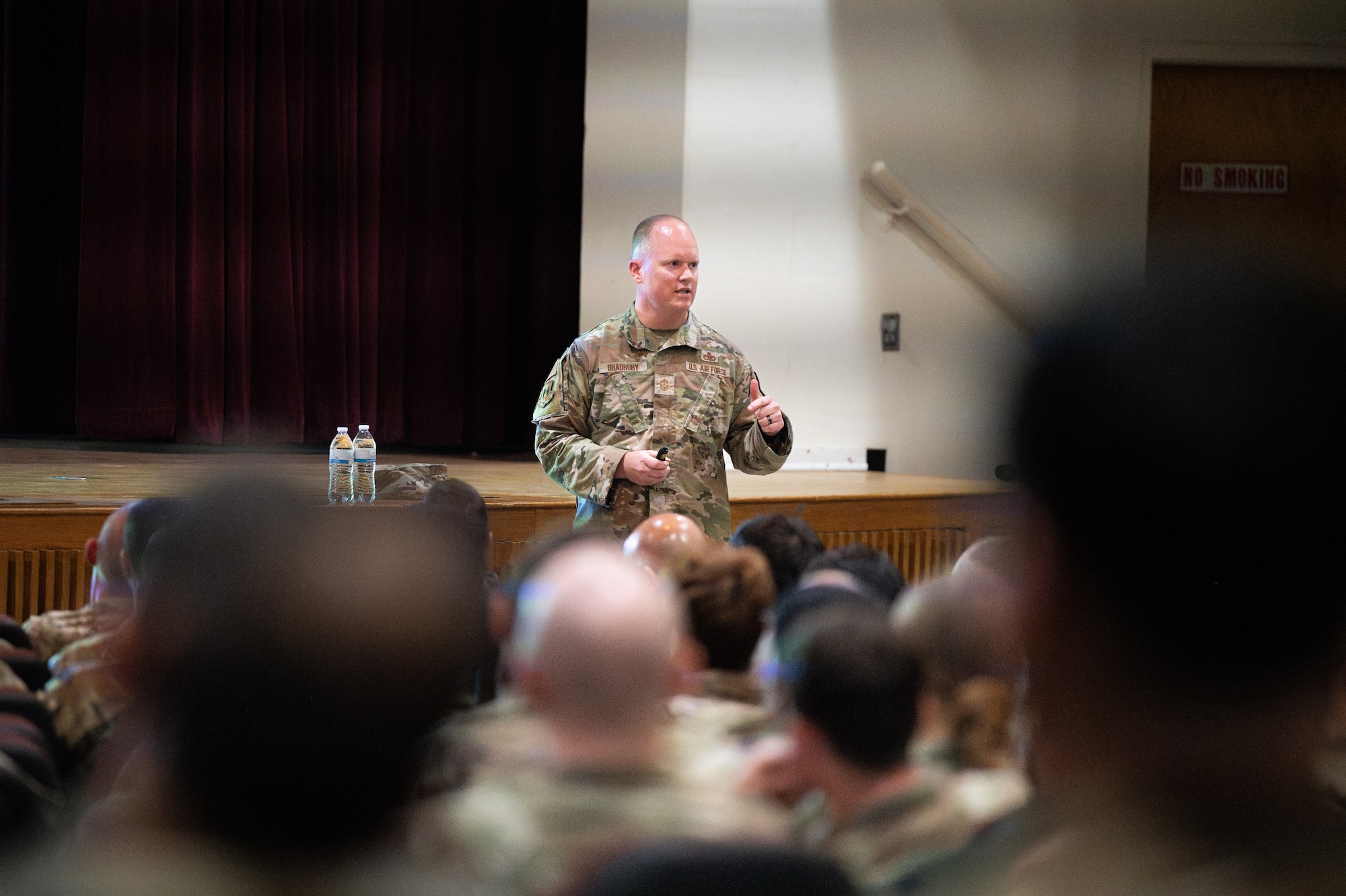 U.S. Air Force Chief Master Sergeant Scott D. Bradbury, 5th Bomb Wing Command Chief, addresses Airmen at an all-call July 23, 2026, at Minot Air Force Base, North Dakota. All-calls, or Commanders' calls, are held to bring members of the unit together to communicate priorities, recognize outstanding performance and provide a forum for Airmen to ask questions directly to leadership.