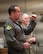U.S. Air Force Col. John E. Burrell, 5th Bomb Wing commander, addresses Airmen an all-call July 23, 2026, at Minot Air Force Base, North Dakota. The commander's call is intended to gather the entire unit to discuss important concerns. (U.S. Air Force photo by Senior Airman Kendra A. Ransum)