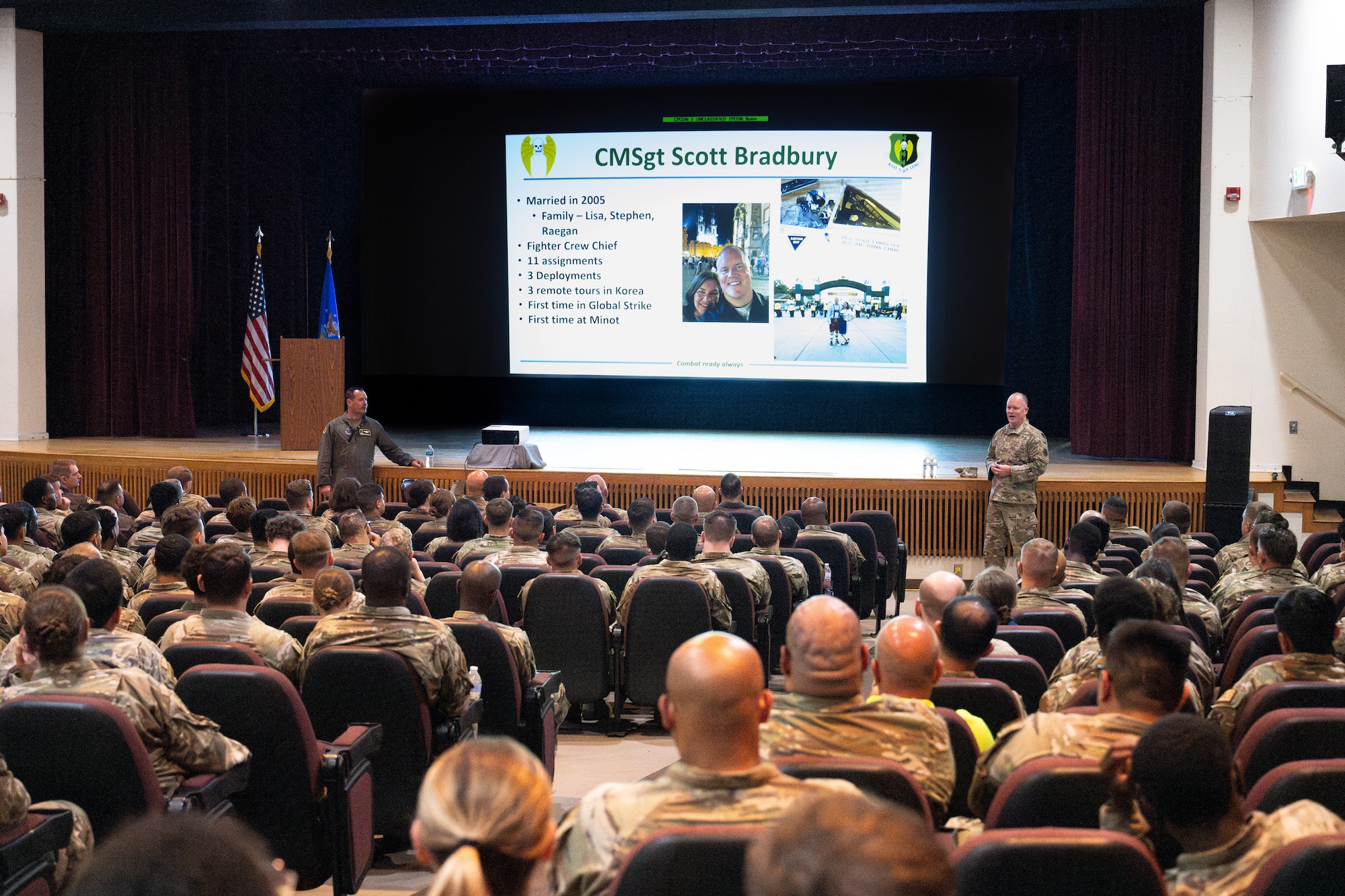 U.S. Air Force Col. John E. Burrell, 5th Bomb Wing commander, addresses members of the 5 BW at an all-call July 23, 2026, at Minot Air Force Base, North Dakota. Burrell also Airmen of current and upcoming wing events, while also answering questions from the audience. (U.S. Air Force photo by Senior Airman Kendra A. Ransum)