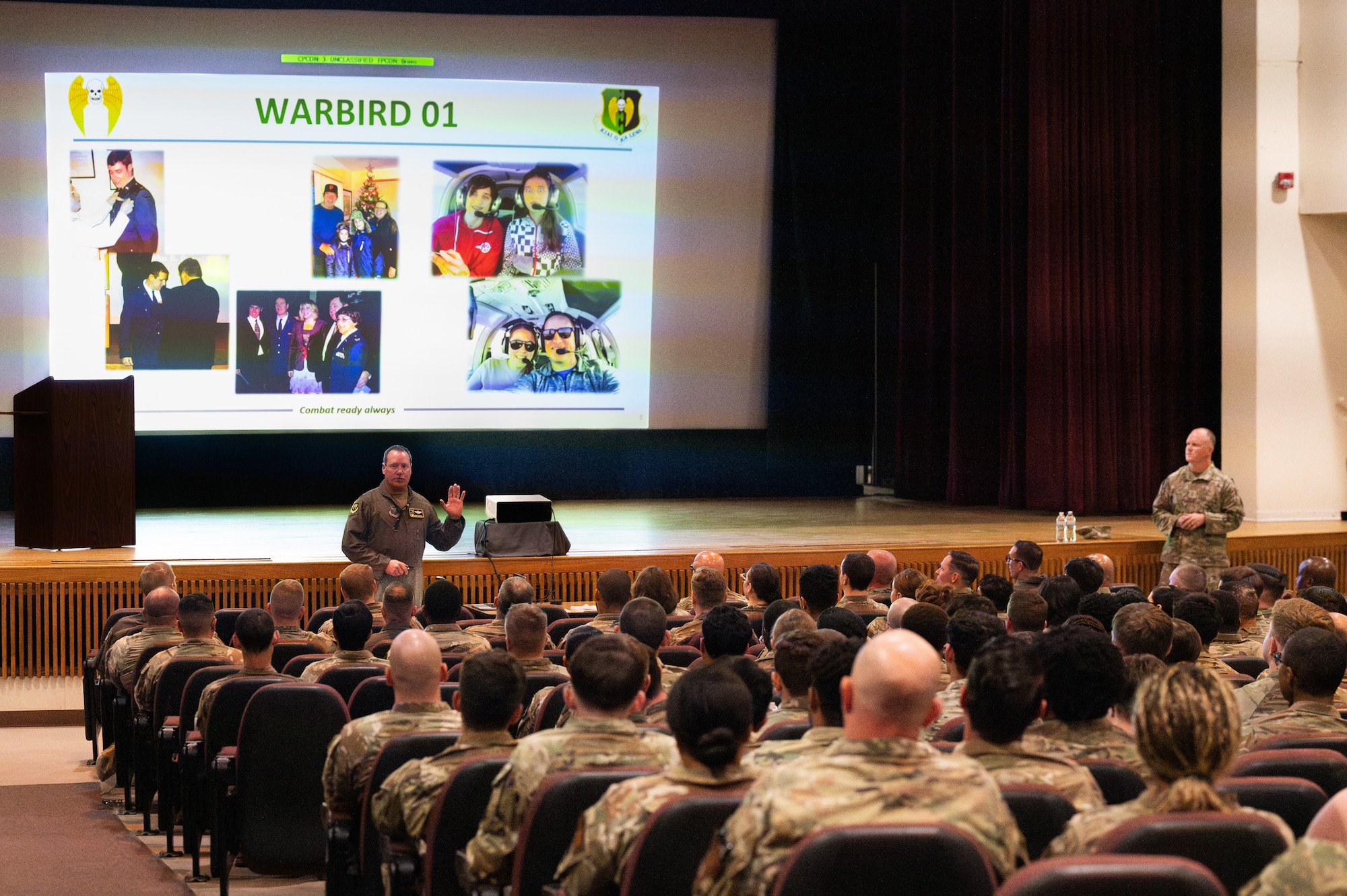 U.S. Air Force Col. John E. Burrell, 5th Bomb Wing commander, addresses members of 5 BW at an all-call July 23, 2026, at Minot Air Force Base, North Dakota. Burrell held the all-call to discuss the wing’s revised Mission, Family and Values lines of effort. (U.S. Air Force photo by Senior Airman Kendra A. Ransum)