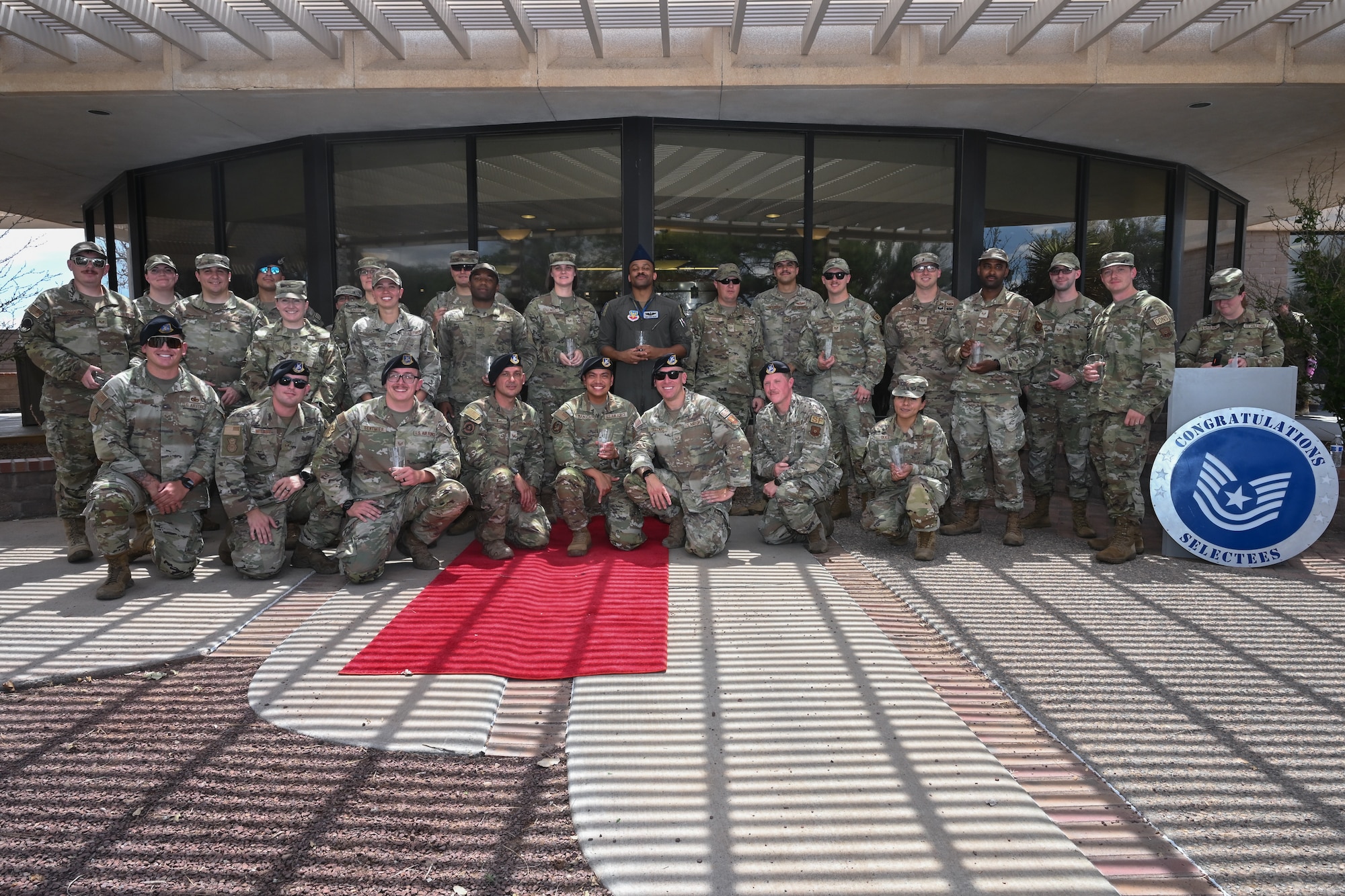 Technical sergeant selects pose for a group photo during a technical sergeant release party at Kirtland Air Force Base.