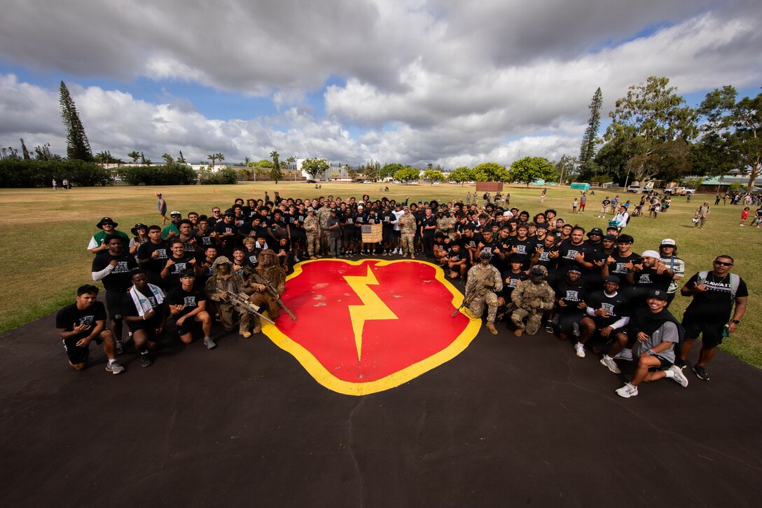 Soldiers from the 25th Infantry Division and players from the University of Hawaii football team pose for a group photo at Weyand Field on Schofield Barracks, Hawaii, July 24, 2026.