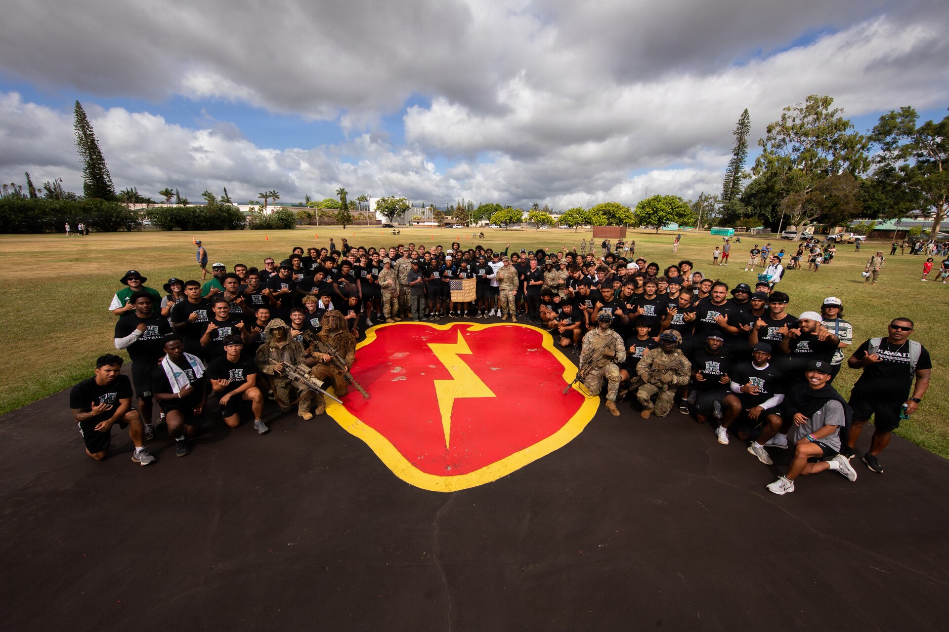 Soldiers from the 25th Infantry Division and players from the University of Hawaii football team pose for a group photo at Weyand Field on Schofield Barracks, Hawaii, July 24, 2026.