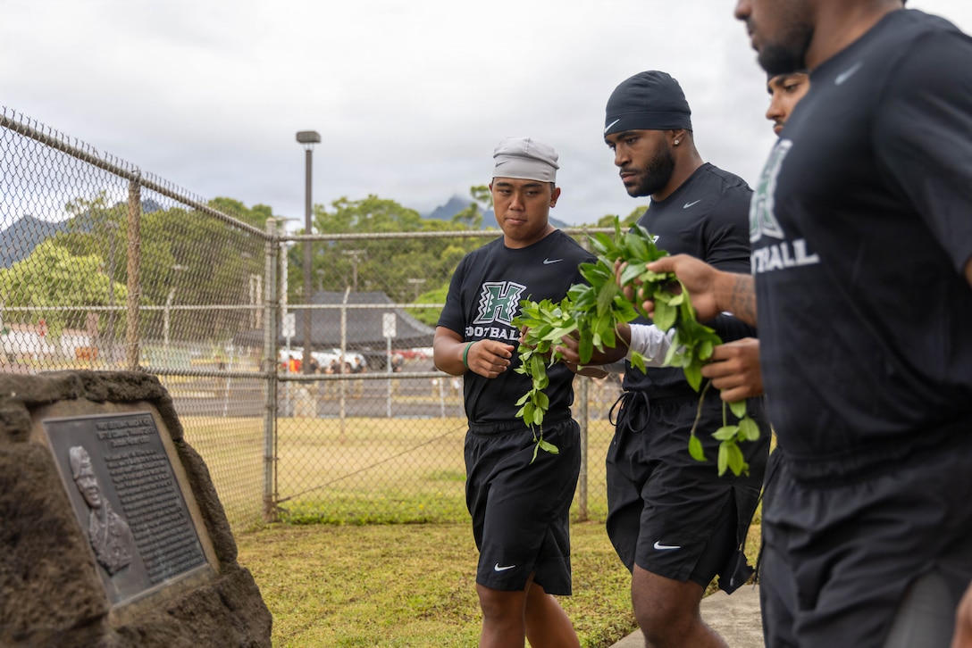 University of Hawaii Rainbow Warrior football players prepare to place a Maile lei on 1Lt. Nainoa K. Hoe memorial stone during the opening ceremony for a team-building day at the 1st Lt. Nainoa Hoe Mission Training Complex on Schofield Barracks, Hawaii, July 24, 2026.