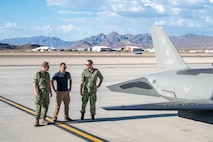 Three members of the Royal Netherlands Air and Space Force observe a U.S. Air Force YFQ-44A Fury aircraft on the flightline.