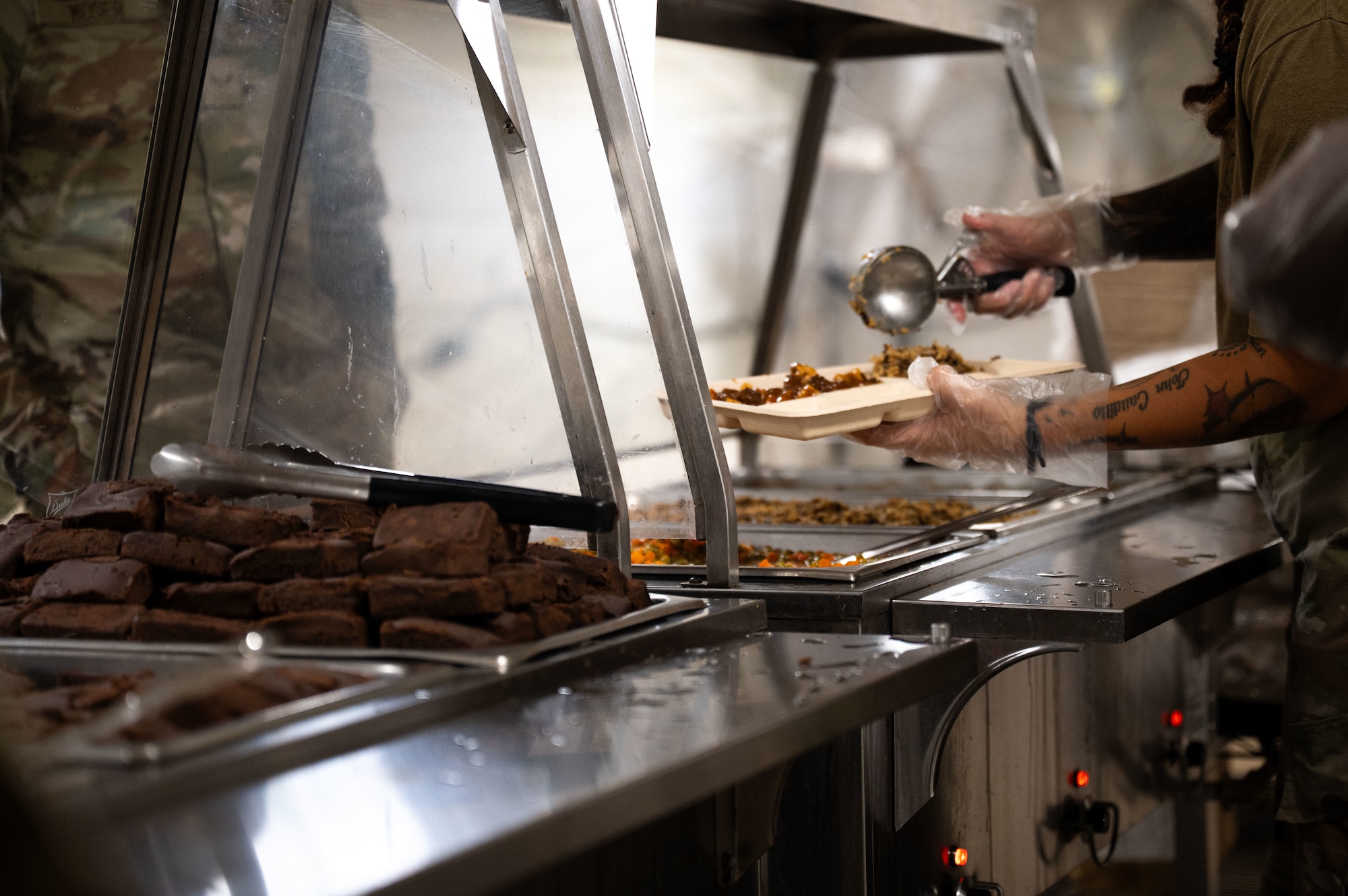 A U.S. Air Force Airman assigned to the 355th Combat Air Base Squadron serves food during Exercise Coyote Storm 26.1 at Tyndall Air Force Base, Florida, July 22, 2026. CS 26.1 gave Airmen hands-on experience in expeditionary operations, from base construction to emergency response. (U.S. Air Force photo by Airman 1st Class Jaden Kidd)
