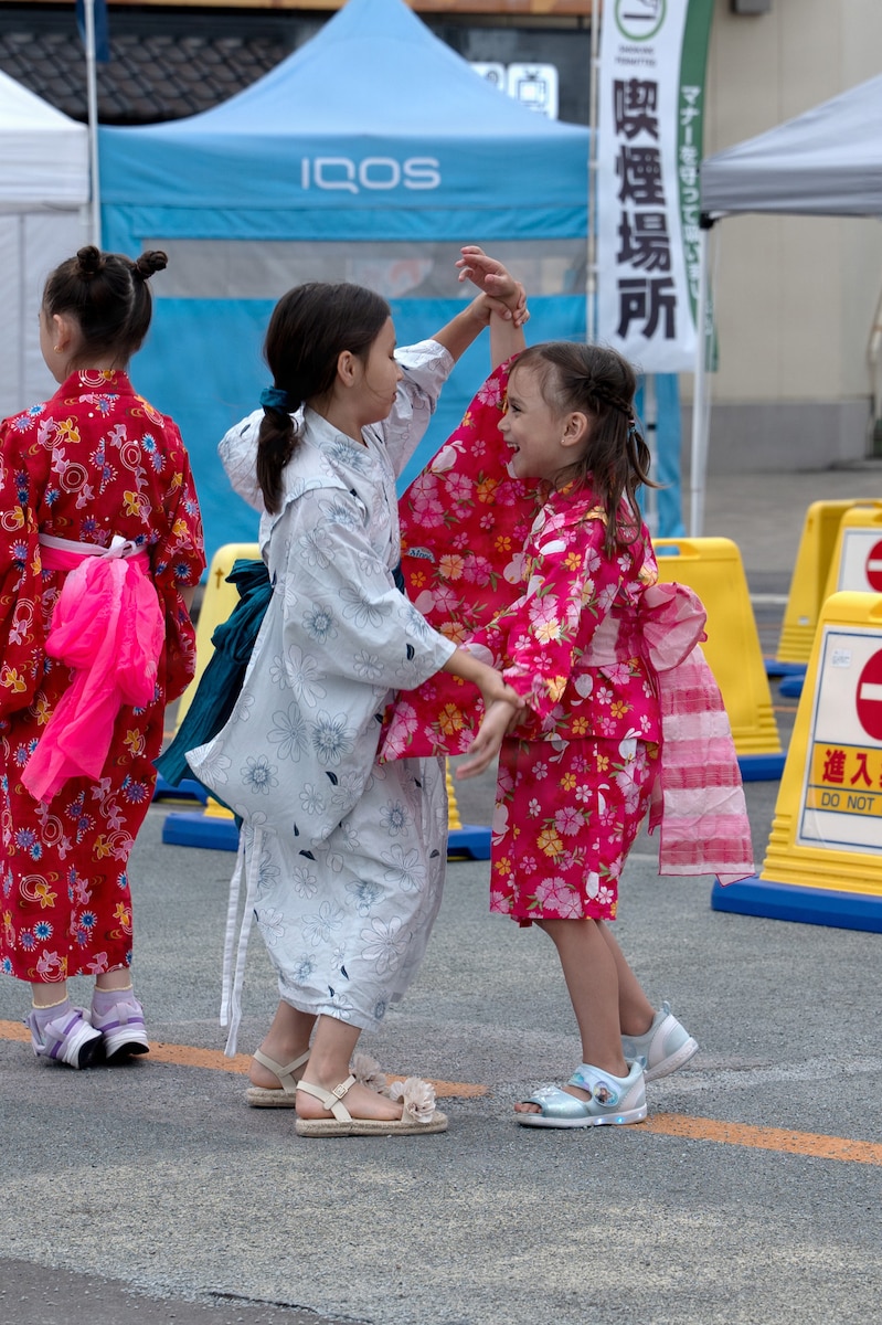 Young girls in yukata dance together at a festival in Japan