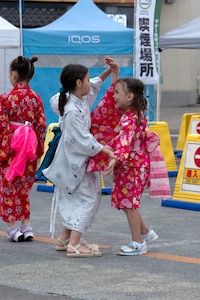Young girls in yukata dance together at a festival in Japan