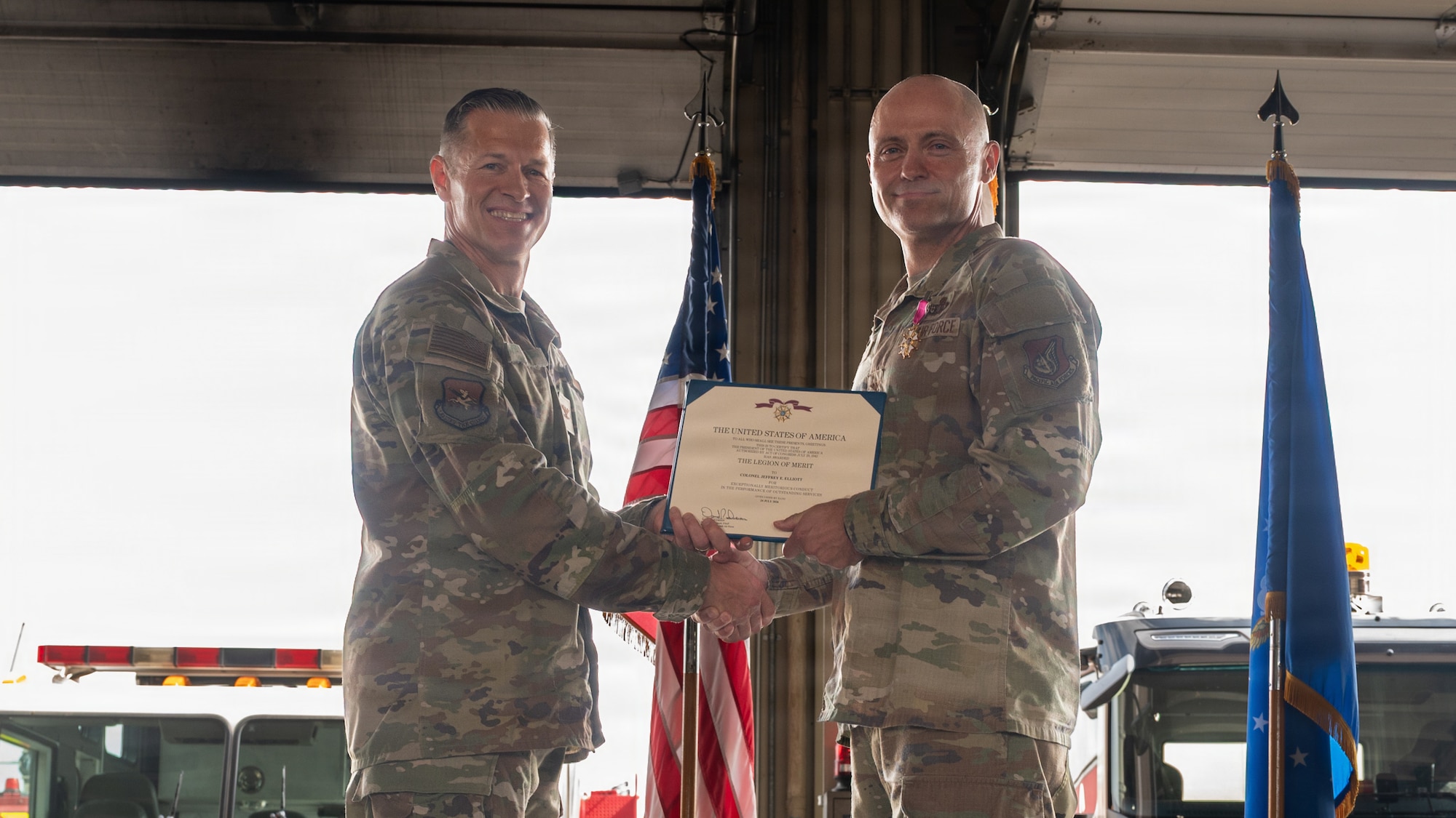 Two people pose with an award.